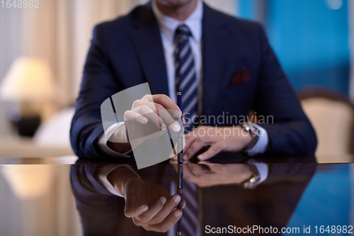 Image of corporate businessman at luxury office pen holding