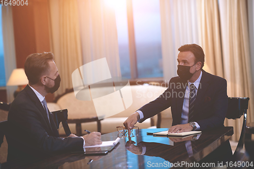 Image of business people wearing crona virus protection face mask on meeting