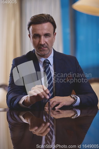 Image of corporate businessman at luxury office pen holding