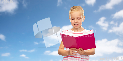 Image of smiling little girl reading book