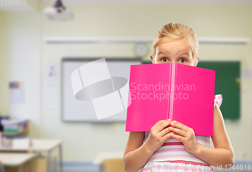 Image of little girl hiding over book