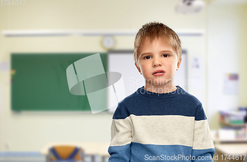 Image of little boy in striped pullover at school