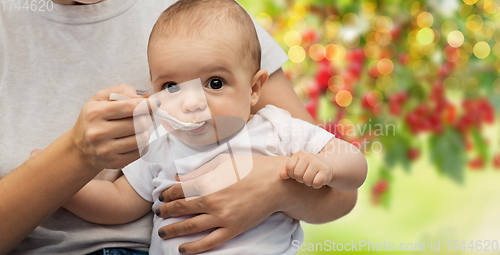 Image of close up of mother with spoon feeding little baby