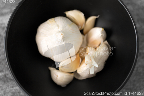 Image of garlic in bowl on slate stone background