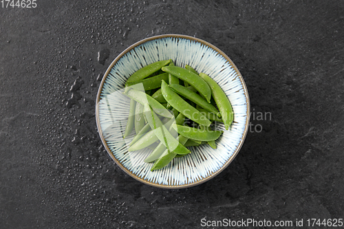 Image of peas in bowl on wet slate stone background