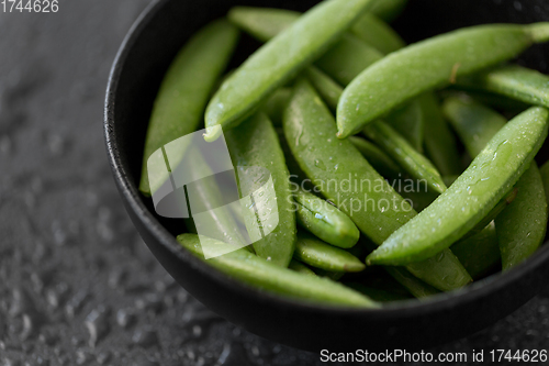 Image of peas in bowl on wet slate stone background
