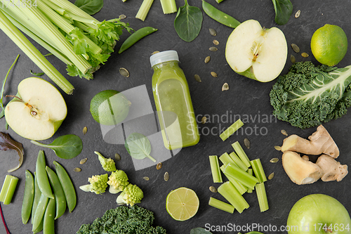 Image of close up of bottle with green juice and vegetables