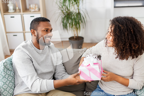 Image of happy couple with gift at home
