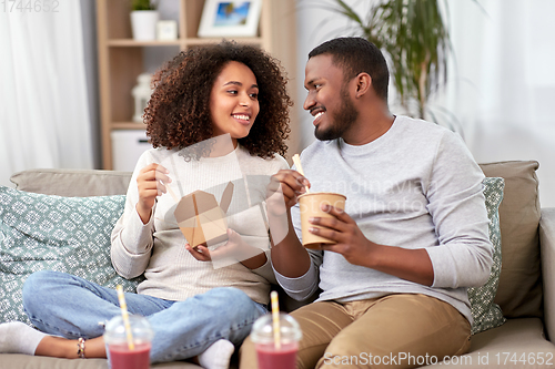 Image of happy couple with takeaway food and drinks at home