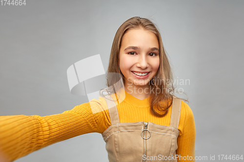 Image of happy teenage girl taking selfie