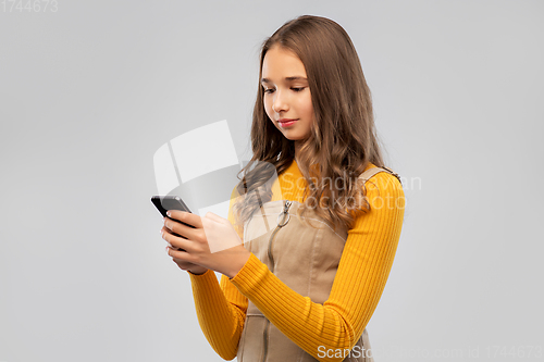 Image of smiling teenage girl using smartphone