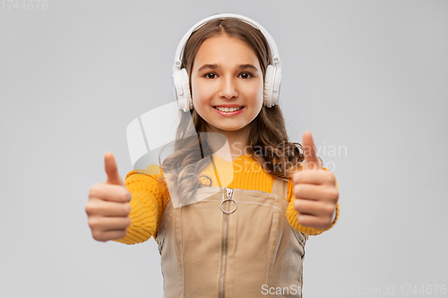 Image of teenage girl in headphones showing thumbs up