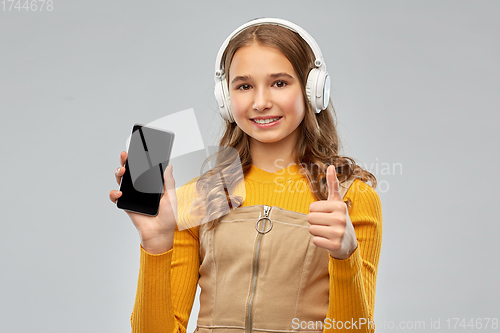 Image of teenage girl in headphones showing smartphone