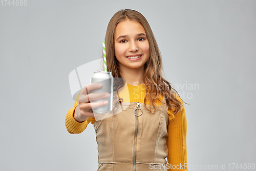 Image of happy teenage girl drinking soda from can