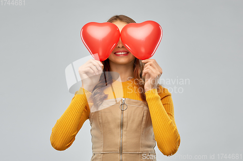 Image of happy teenage girl with red heart-shaped balloons