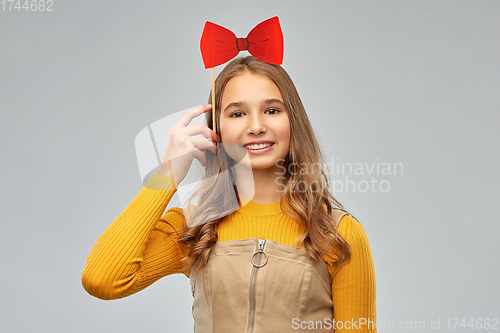 Image of happy teenage girl with red bowtie party accessory