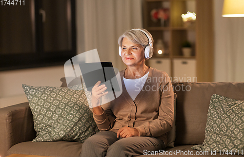 Image of senior woman in headphones listening to music