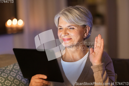 Image of happy old woman with tablet pc having video call