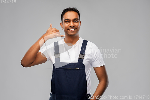 Image of happy worker or builder making phone call gesture