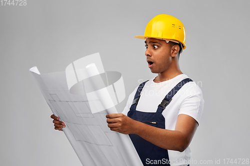 Image of shocked indian builder in helmet with blueprint