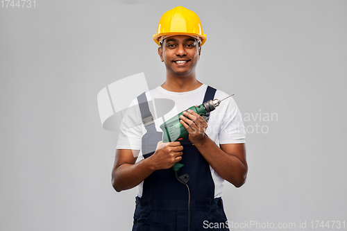 Image of happy indian builder in helmet with electric drill