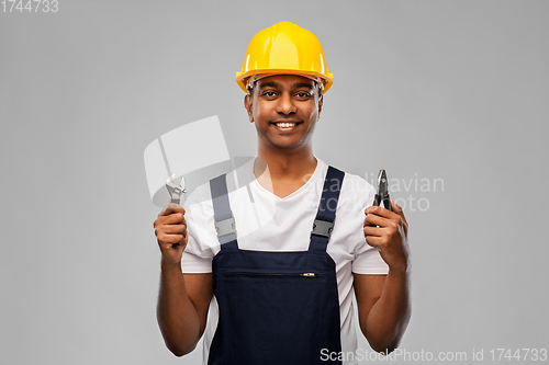 Image of indian builder in helmet with wrench and pliers