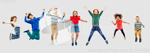 Image of happy children jumping in air over grey background