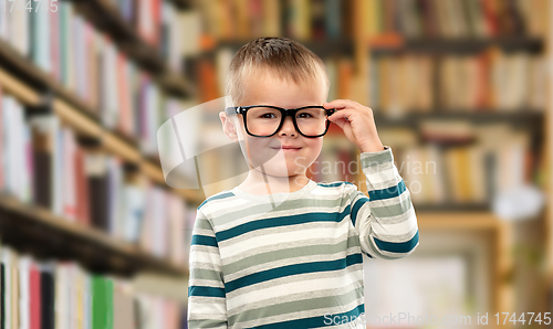 Image of portrait of smiling boy in glasses over library