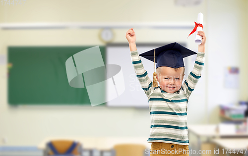 Image of little boy in mortar board with diploma at school