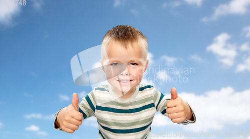 Image of smiling boy in striped shirt showing thumbs up