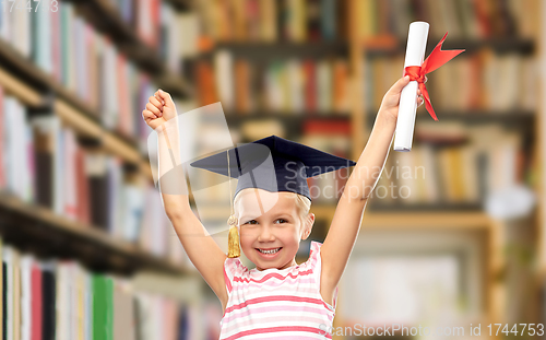 Image of happy little girl in mortarboard with diploma