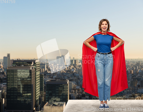 Image of happy woman in red superhero cape over tokyo city