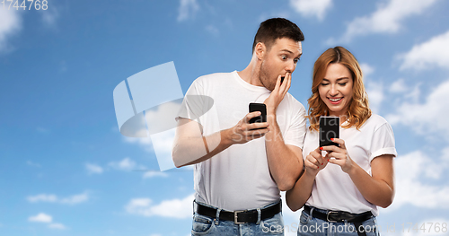 Image of happy couple in white t-shirts with smartphones