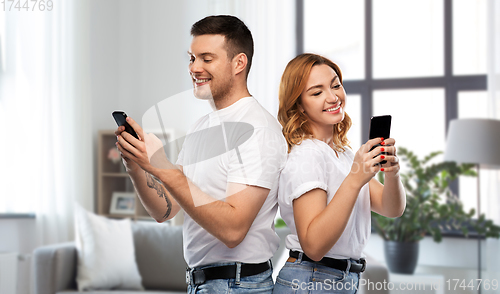 Image of happy couple in white t-shirts with smartphones