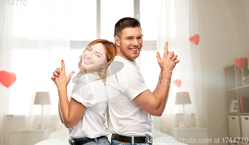 Image of happy couple making gun gesture on valentines day