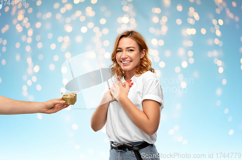 Image of happy couple in white t-shirts with christmas gift