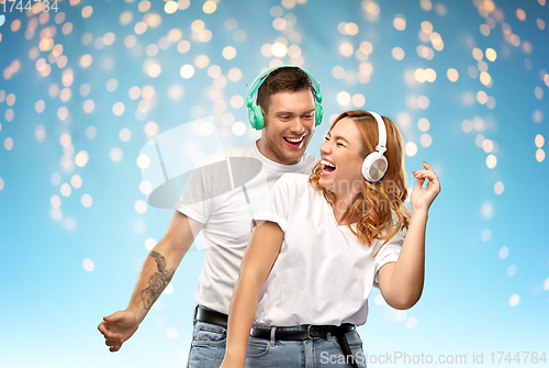 Image of happy couple in headphones dancing