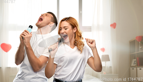 Image of happy couple singing to hairbrush and lotion