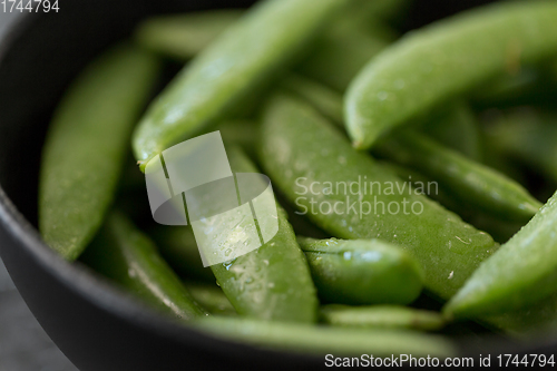 Image of peas in bowl on wet slate stone background