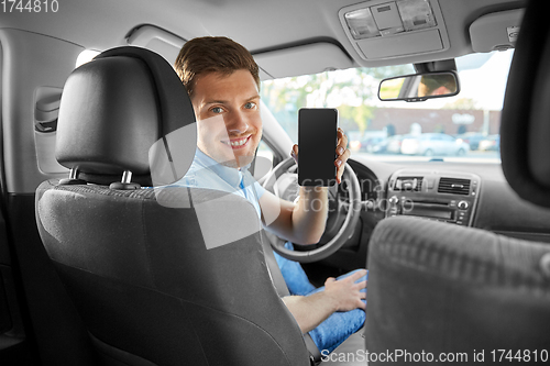 Image of man or car driver showing smartphone