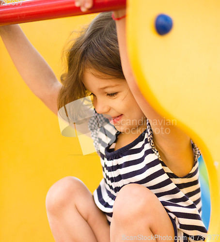 Image of Cute little girl is playing in playground