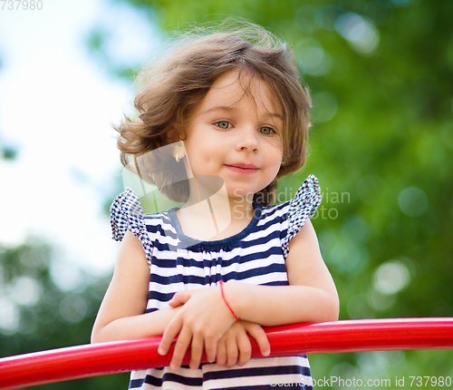 Image of Cute little girl is playing in playground