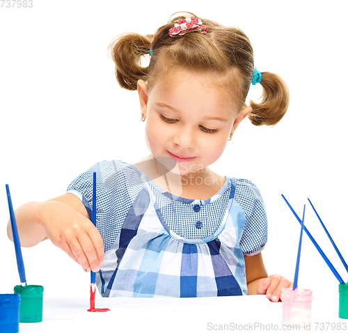 Image of Little girl is painting with gouache