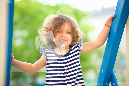 Image of Cute little girl is playing in playground