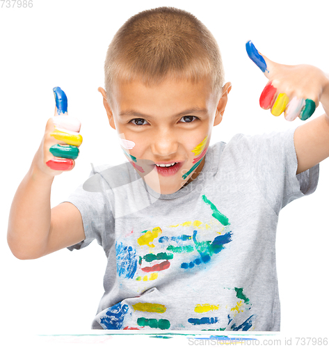Image of Portrait of a cute boy playing with paints