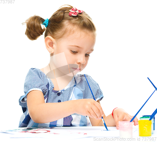 Image of Little girl is painting with gouache