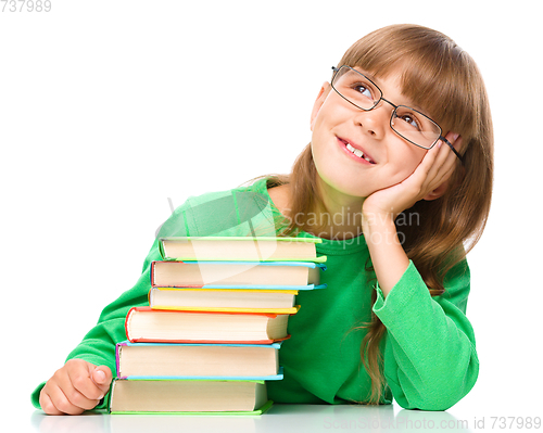 Image of Young girl is daydreaming while reading book