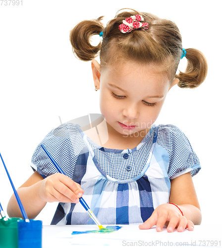 Image of Little girl is painting with gouache