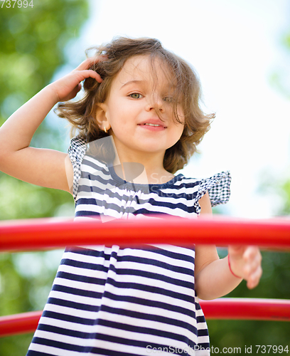 Image of Cute little girl is playing in playground