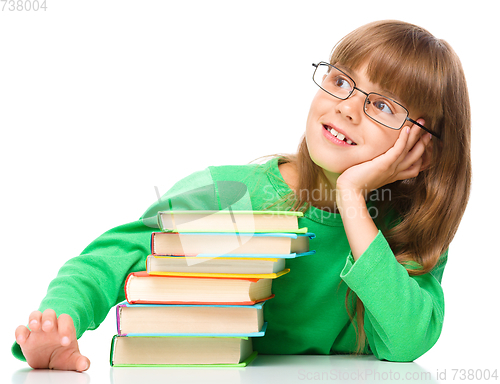 Image of Young girl is daydreaming while reading book